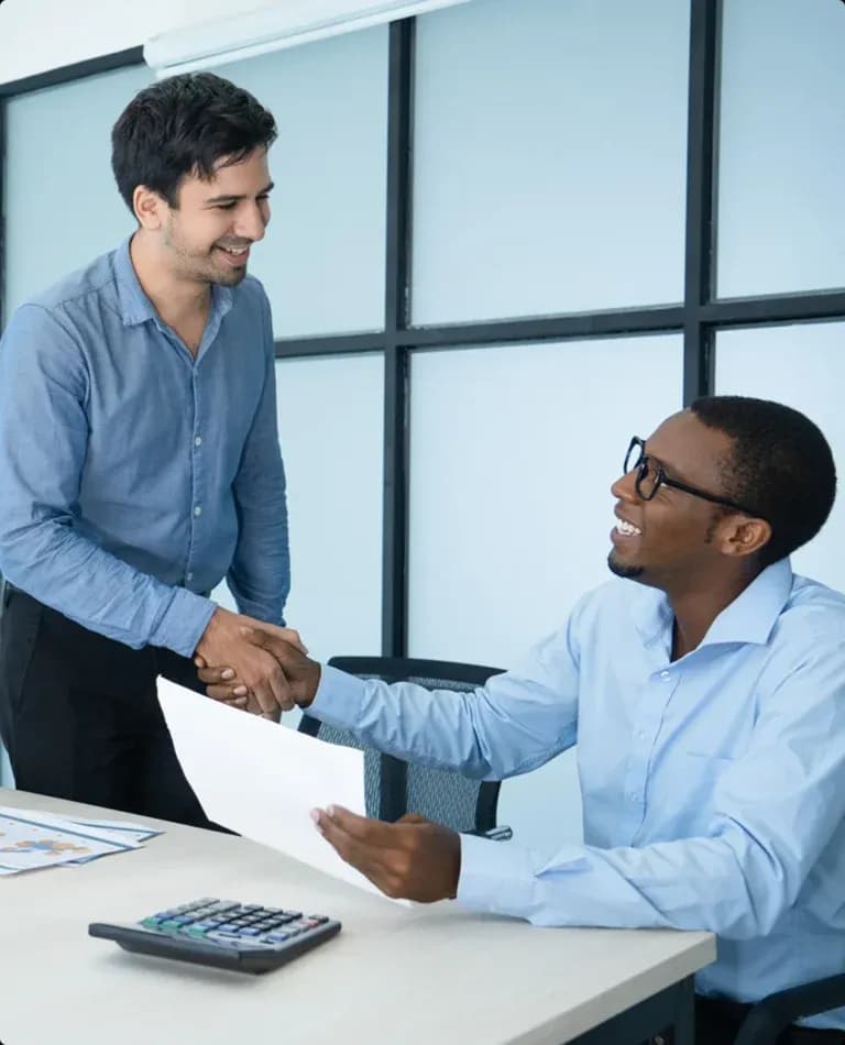 Two professionals reviewing a contractor estimate and shaking hands Two professionals reviewing a contractor estimate and shaking hands