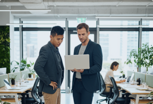 Trust Patrick's members discuss content on a laptop in a modern office. They appear focused.